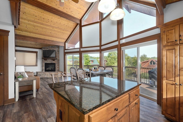 kitchen featuring beamed ceiling, a kitchen island, wood ceiling, a fireplace, and high vaulted ceiling