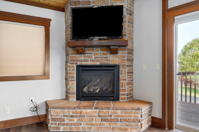 details featuring hardwood / wood-style floors and a large fireplace