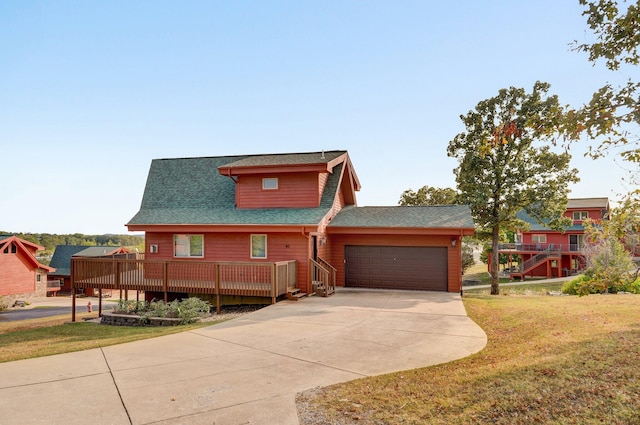 view of front of house featuring a deck, a front yard, and a garage