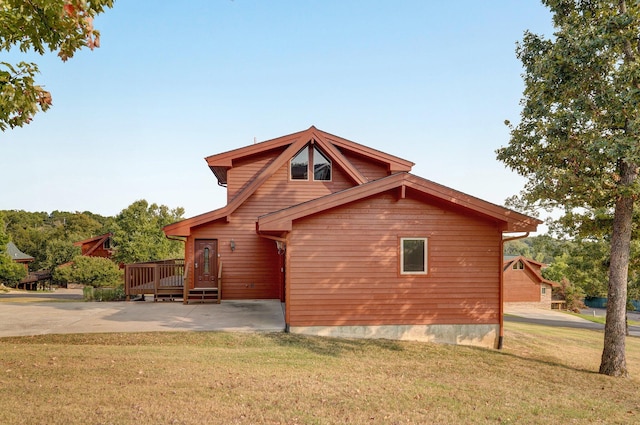 view of side of home featuring a lawn and a deck