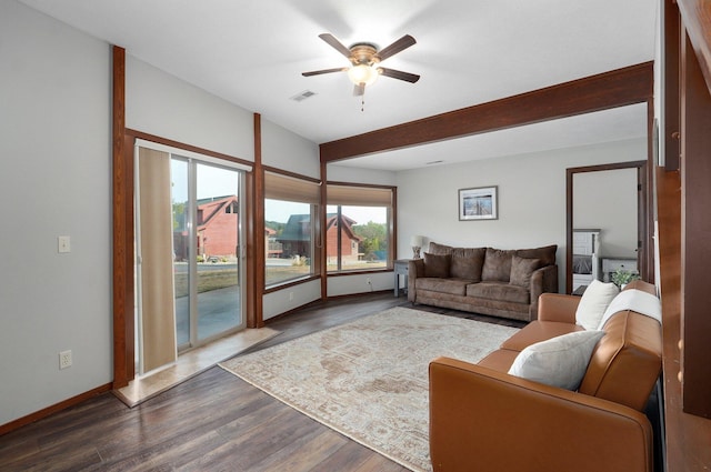 living room featuring beamed ceiling, hardwood / wood-style floors, and ceiling fan