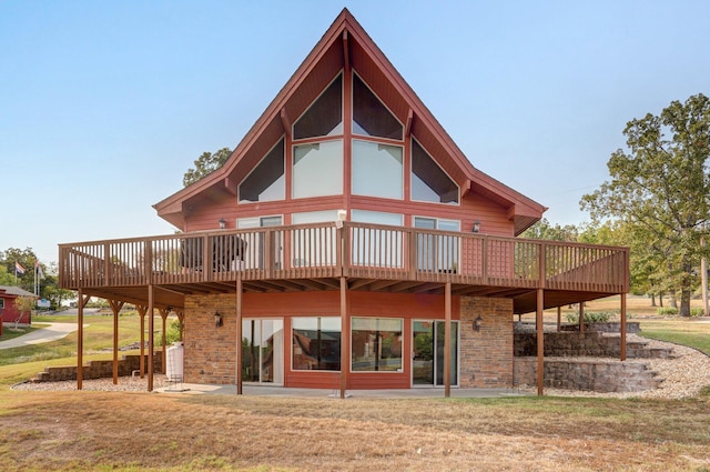 back of house featuring a deck and a lawn