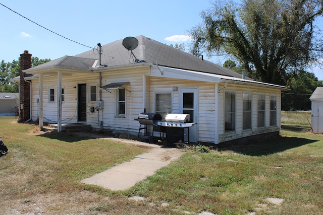 back of house with a lawn