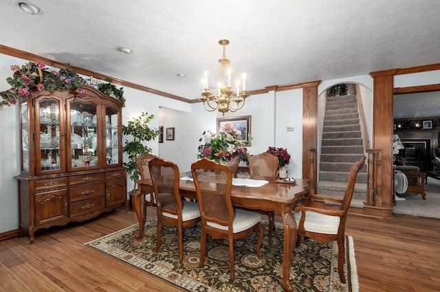 dining room with hardwood / wood-style flooring, crown molding, and a chandelier