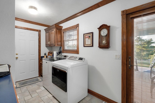 laundry room with cabinets, crown molding, and washing machine and clothes dryer