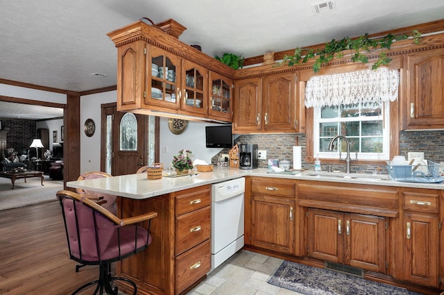 1568 Glossip Ave, Highlandville, MO 65669 - kitchen featuring dishwasher, a sink, a peninsula, brown cabinets, and a textured ceiling