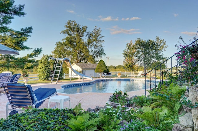 view of pool featuring a water slide and a patio area