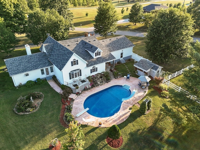 view of swimming pool with a storage shed, a lawn, a patio, and a diving board