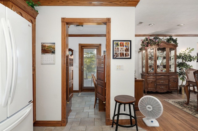 interior space with ornamental molding and light hardwood / wood-style floors