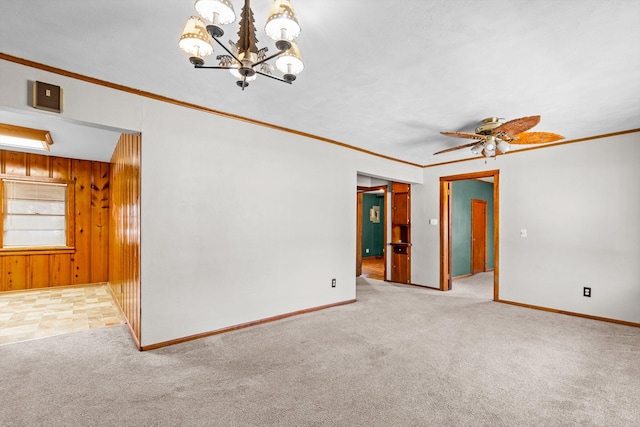 unfurnished room featuring light carpet, ceiling fan with notable chandelier, wooden walls, and crown molding