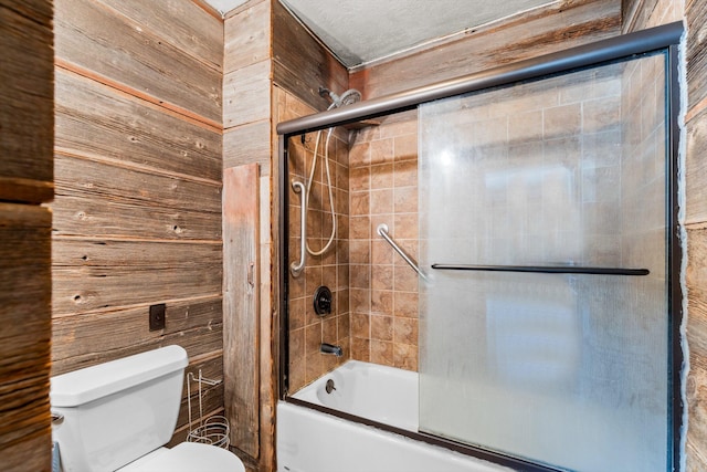 bathroom featuring wooden walls, toilet, and enclosed tub / shower combo