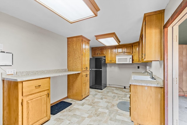 kitchen with black refrigerator and sink