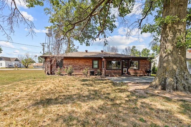 view of front of property featuring a patio, a front yard, and cooling unit