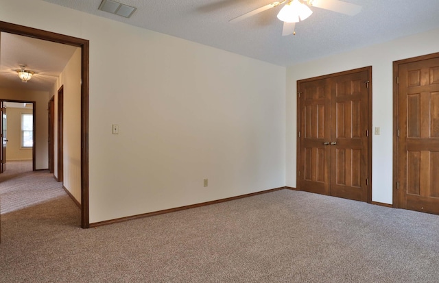 unfurnished bedroom featuring ceiling fan, carpet floors, and a textured ceiling