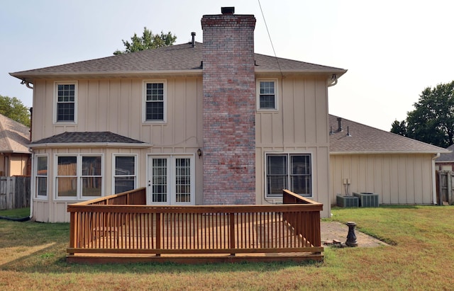 rear view of house with a wooden deck and a yard