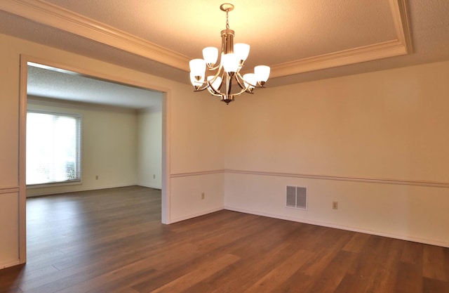 spare room with dark hardwood / wood-style floors, crown molding, a notable chandelier, and a textured ceiling