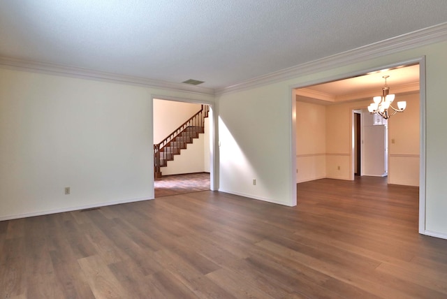 spare room with a notable chandelier, crown molding, dark wood-type flooring, and a textured ceiling