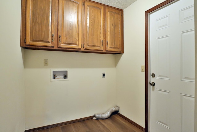 laundry room featuring hookup for an electric dryer, a textured ceiling, cabinets, hookup for a washing machine, and hardwood / wood-style floors