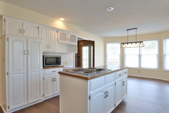 kitchen with stainless steel appliances, dark hardwood / wood-style floors, a center island, and white cabinetry