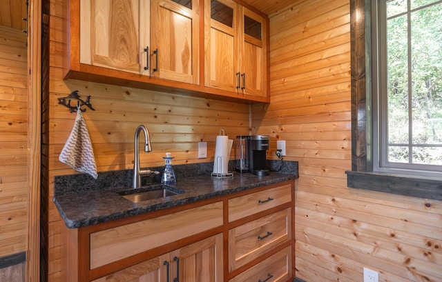 1326 Bald Eagle Dr, Galena, MO 65656 - kitchen featuring glass insert cabinets, wood walls, dark stone counters, and a sink