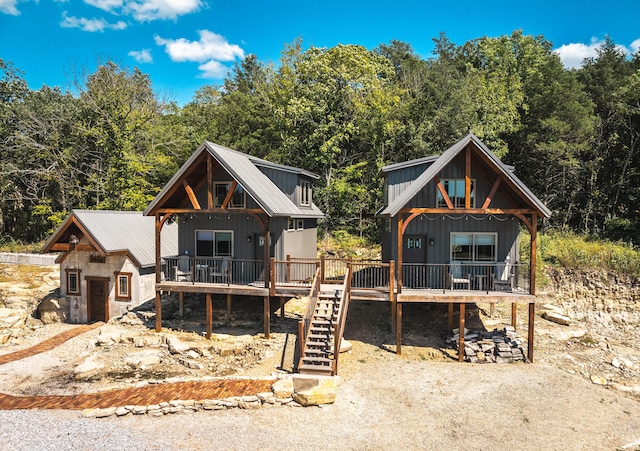 1326 Bald Eagle Dr, Galena, MO 65656 - view of front facade featuring board and batten siding, an outbuilding, metal roof, a wooden deck, and stairs