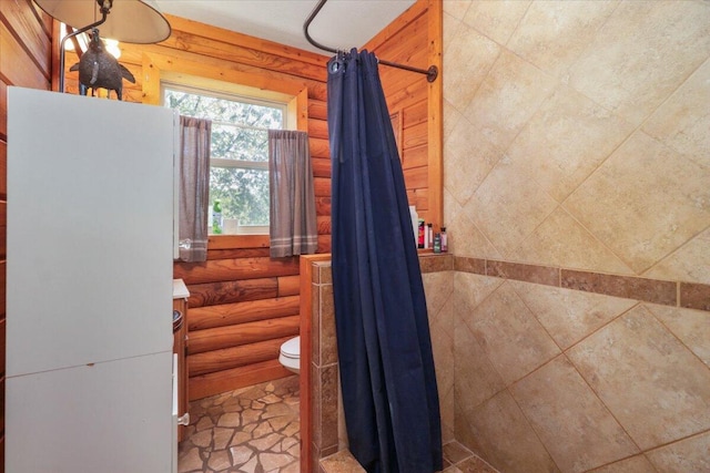 bathroom with log walls, curtained shower, vanity, and toilet