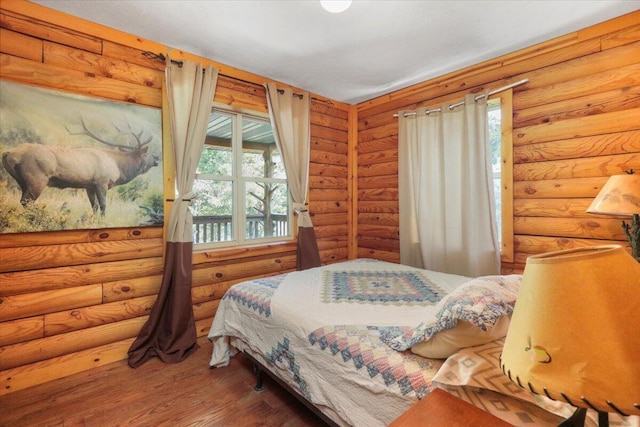 bedroom with dark hardwood / wood-style floors and rustic walls