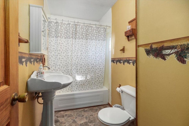 bathroom featuring shower / bath combo with shower curtain and toilet