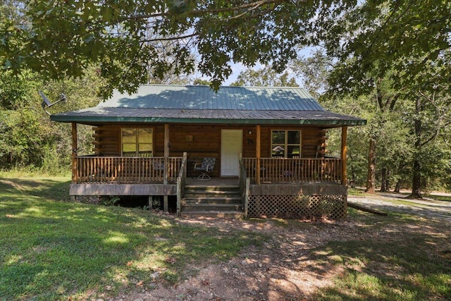 cabin with a front yard and covered porch