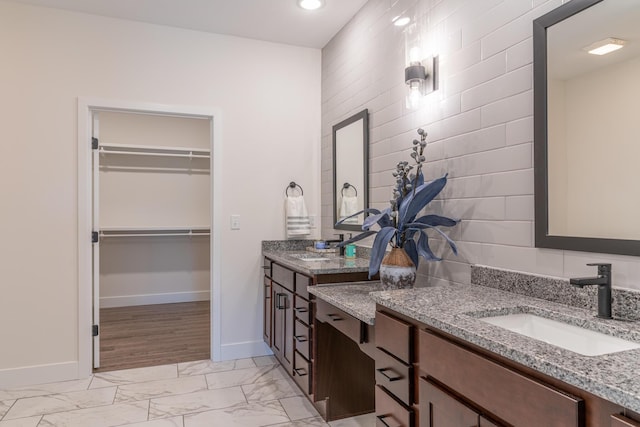 5955 S Farm Rd 163 203B, Springfield, MO 65810 - bathroom featuring two vanities, marble finish floor, baseboards, and a sink