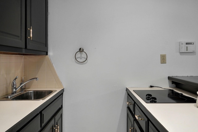 kitchen featuring gray cabinets, sink, tasteful backsplash, and black electric stovetop