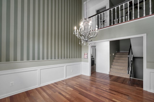 unfurnished dining area with a chandelier and hardwood / wood-style flooring