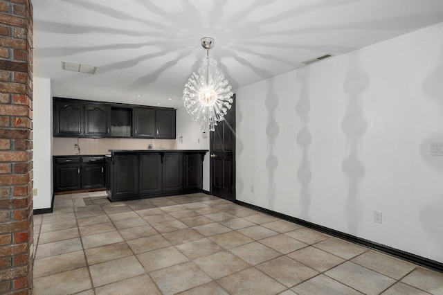 kitchen featuring light tile patterned flooring, pendant lighting, and a chandelier