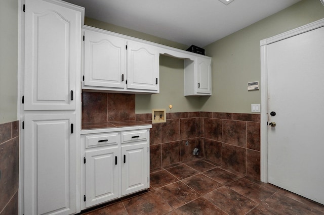 laundry area with hookup for a washing machine, tile walls, and cabinets