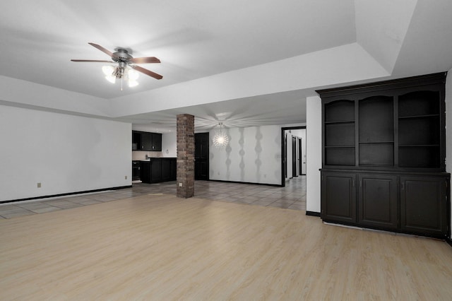 unfurnished living room featuring ceiling fan, light wood-type flooring, and decorative columns