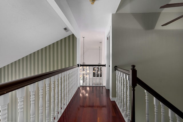 hallway featuring a chandelier, vaulted ceiling, and dark hardwood / wood-style flooring