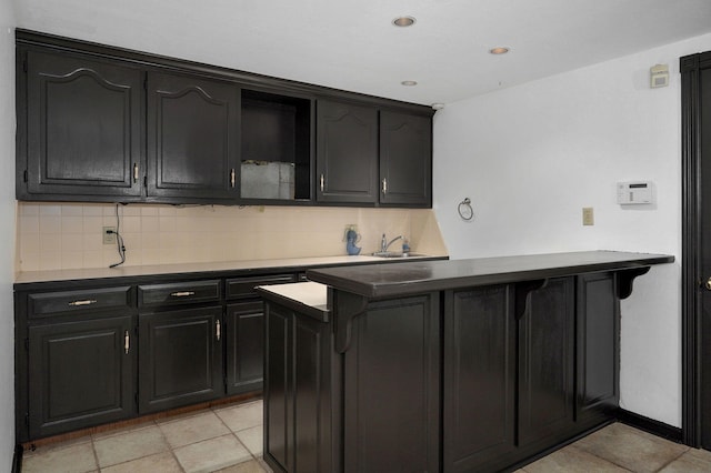 kitchen featuring light tile patterned floors, backsplash, and sink