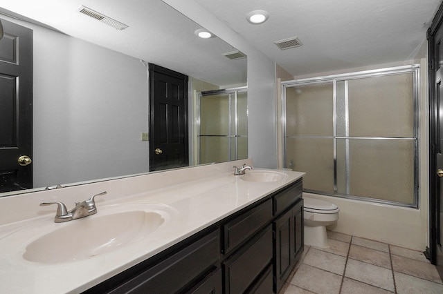 full bathroom with shower / bath combination with glass door, vanity, toilet, and tile patterned floors