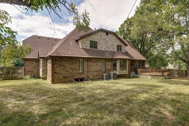 back of house with a yard and central air condition unit