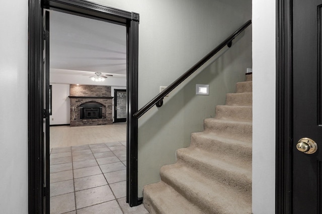 staircase with ceiling fan and tile patterned flooring