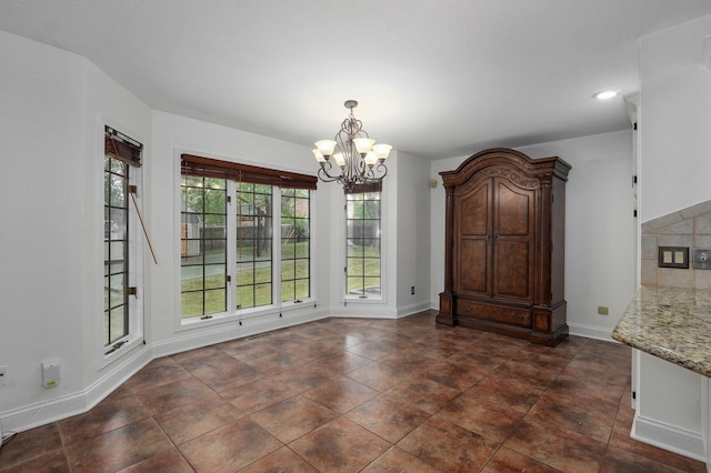 unfurnished dining area with a notable chandelier