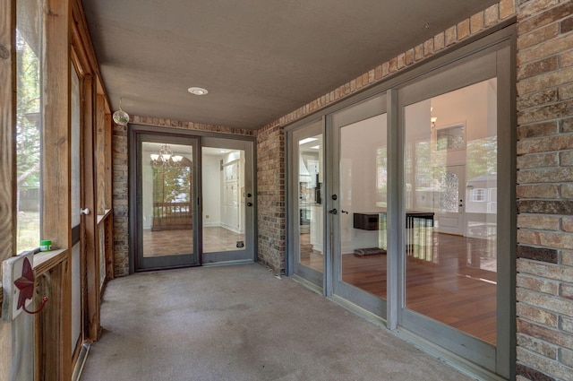 unfurnished sunroom featuring a wealth of natural light and a chandelier