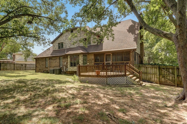 back of house featuring cooling unit, a deck, and a lawn