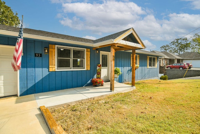 view of front facade featuring a front yard, a garage, and covered porch