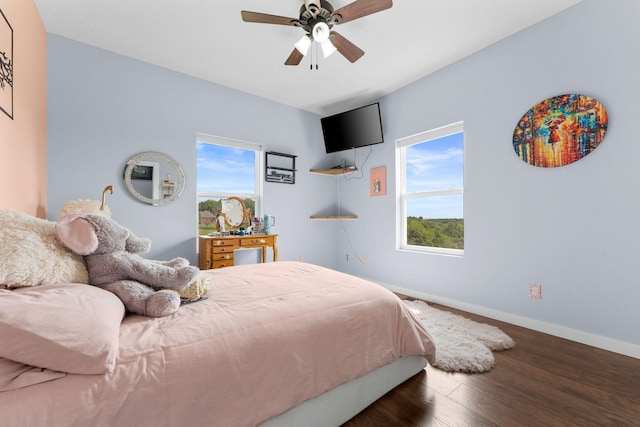 bedroom with dark hardwood / wood-style flooring, multiple windows, and ceiling fan