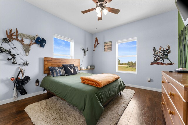 bedroom featuring multiple windows, ceiling fan, and dark wood-type flooring