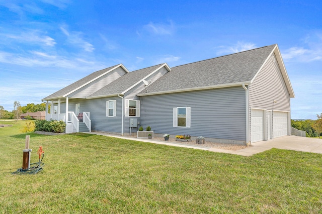 rear view of house featuring a garage, a lawn, and covered porch