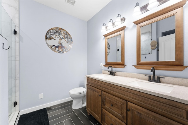 bathroom with a shower with shower door, vanity, and toilet