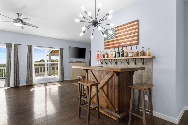 bar with dark wood-type flooring and ceiling fan with notable chandelier