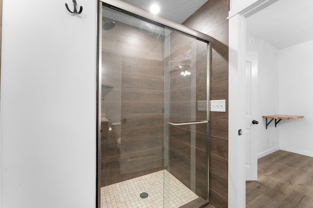 bathroom with walk in shower and hardwood / wood-style flooring